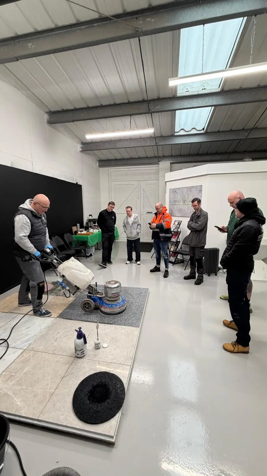 Professional floor polishing machine demonstration during AK Surface Solutions training